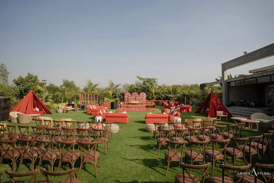 Rows of chairs and a stage set out on a wide lawn in daylight
