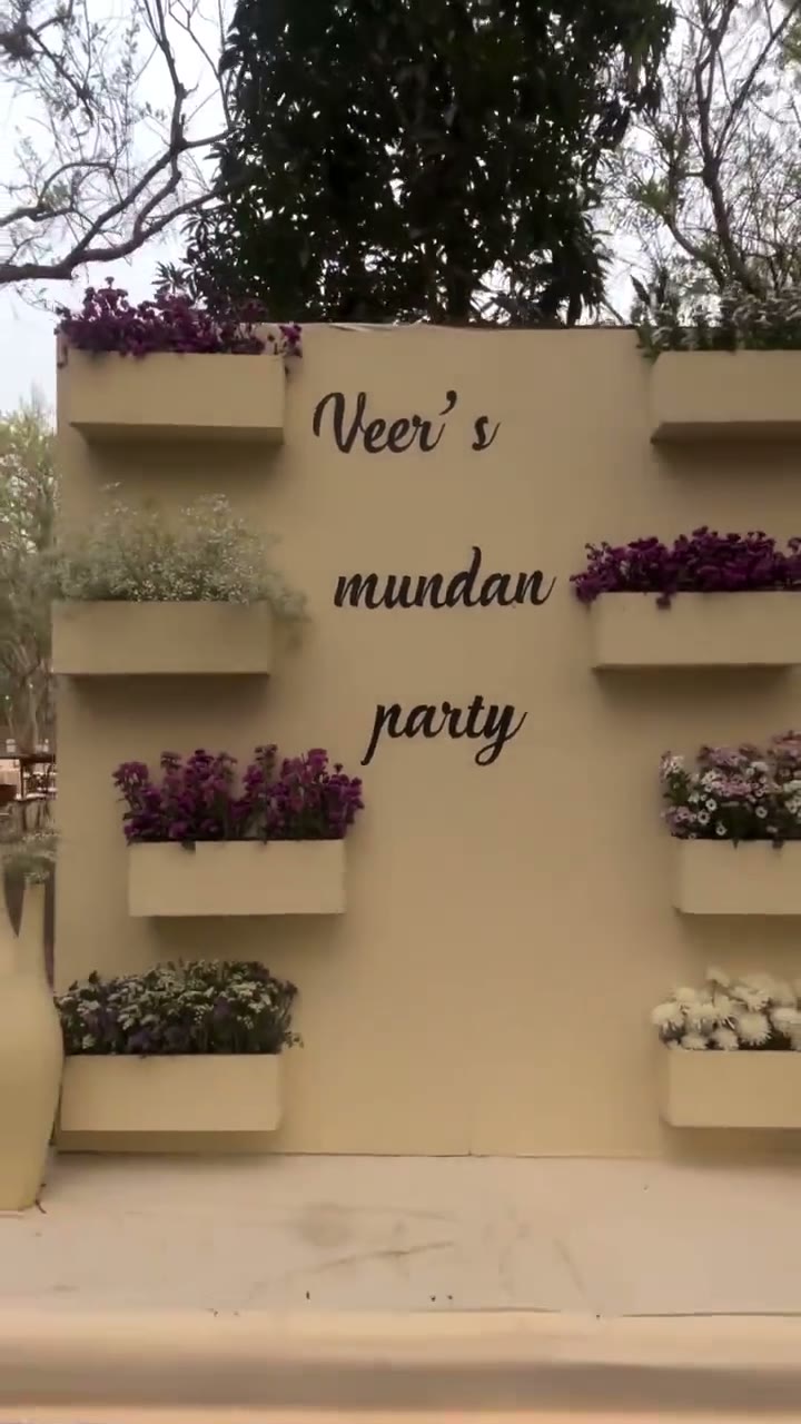 A family gathers for a mundan ceremony among potted greenery