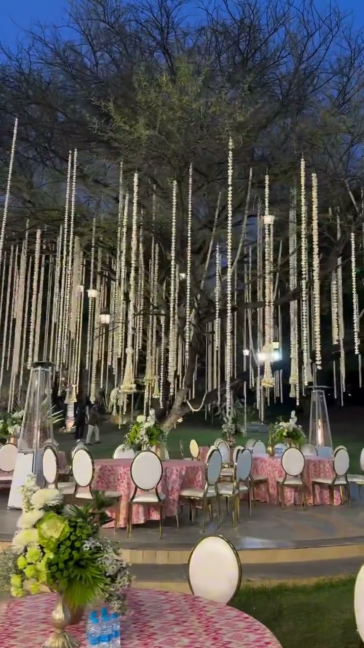 An evening wedding lit across a lakeside palace venue
